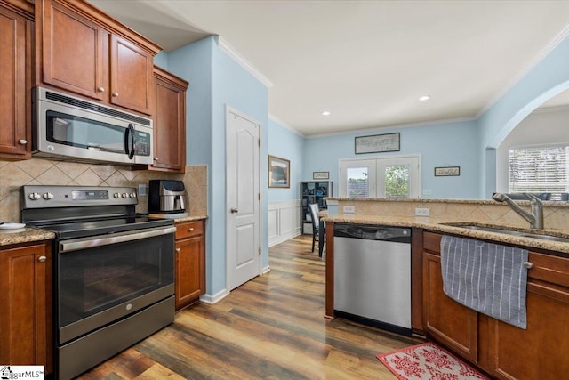 114 Eagles View Ct, Easley, SC 29642 - kitchen featuring appliances with stainless steel finishes, ornamental molding, dark wood-type flooring, tasteful backsplash, and arched walkways