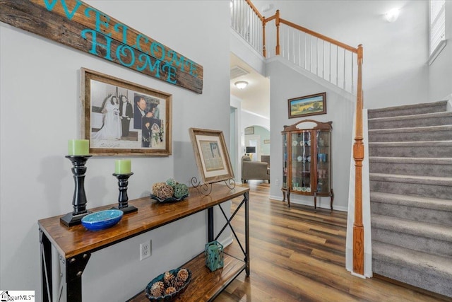 114 Eagles View Ct, Easley, SC 29642 - staircase featuring arched walkways, wood finished floors, and a towering ceiling