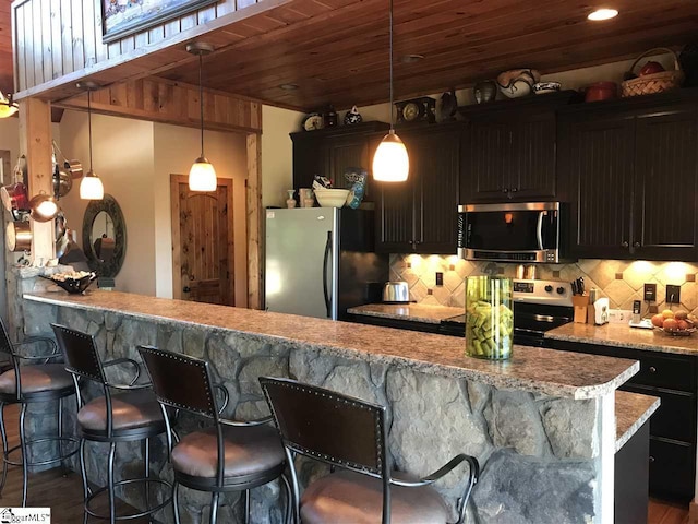 kitchen featuring backsplash, hanging light fixtures, wood ceiling, and stainless steel appliances