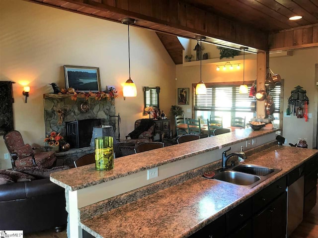 kitchen featuring decorative light fixtures, wooden ceiling, a stone fireplace, light stone countertops, and sink