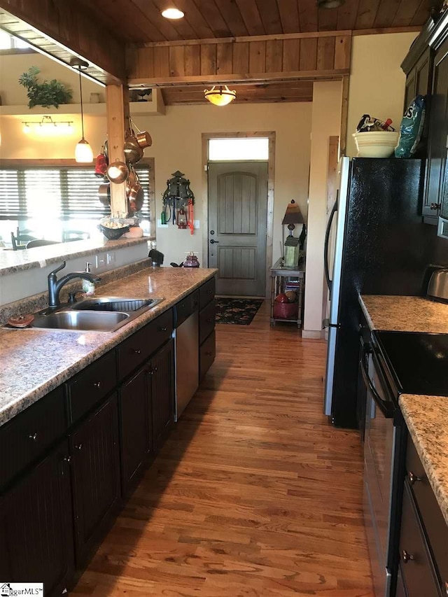 kitchen with hardwood / wood-style floors, decorative light fixtures, wood ceiling, and sink