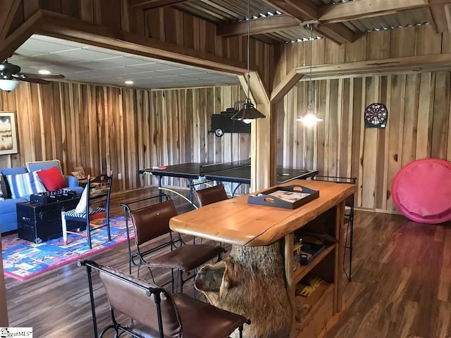 interior space featuring ceiling fan, wood walls, and dark wood-type flooring