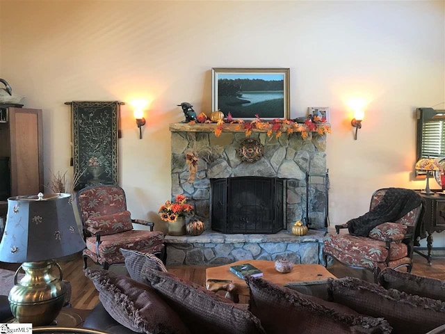 living room featuring a stone fireplace and hardwood / wood-style flooring