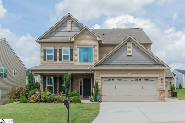 craftsman-style home with covered porch, a front yard, and a garage