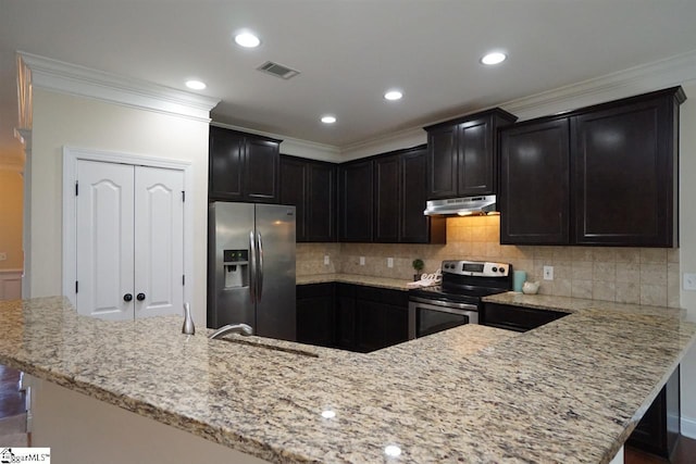 kitchen with tasteful backsplash, ornamental molding, appliances with stainless steel finishes, and light stone countertops