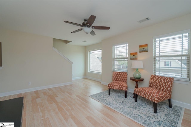 living area with light hardwood / wood-style floors and ceiling fan