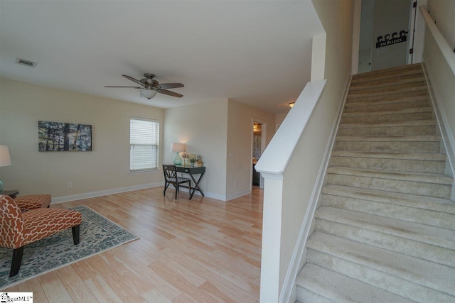 stairs featuring ceiling fan and light wood-type flooring