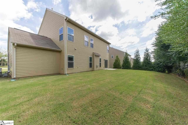 rear view of house featuring a yard