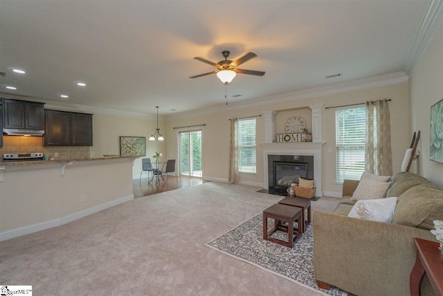 living room featuring plenty of natural light, ceiling fan with notable chandelier, and light colored carpet