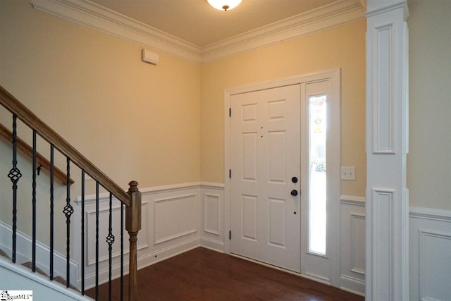 foyer entrance with crown molding, decorative columns, and dark hardwood / wood-style flooring