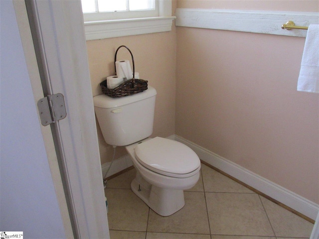 bathroom with toilet and tile floors