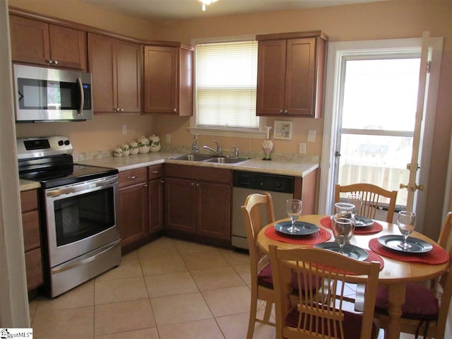 kitchen with light tile flooring, stainless steel appliances, and sink