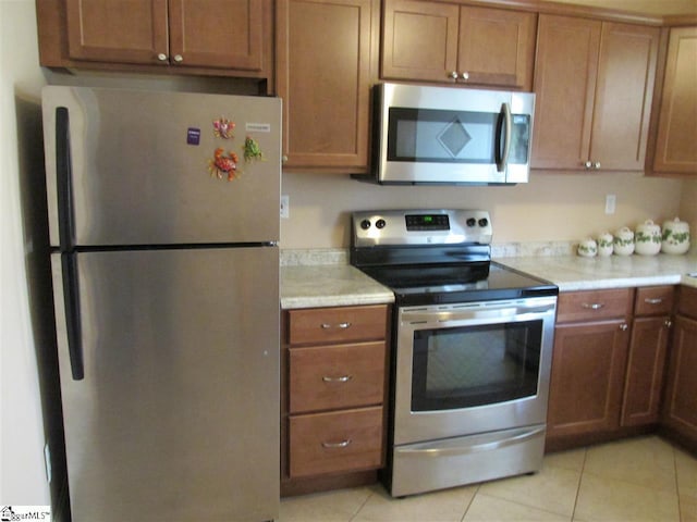 kitchen featuring stainless steel appliances and light tile floors