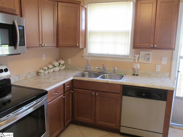 kitchen featuring sink, stainless steel appliances, and light tile floors