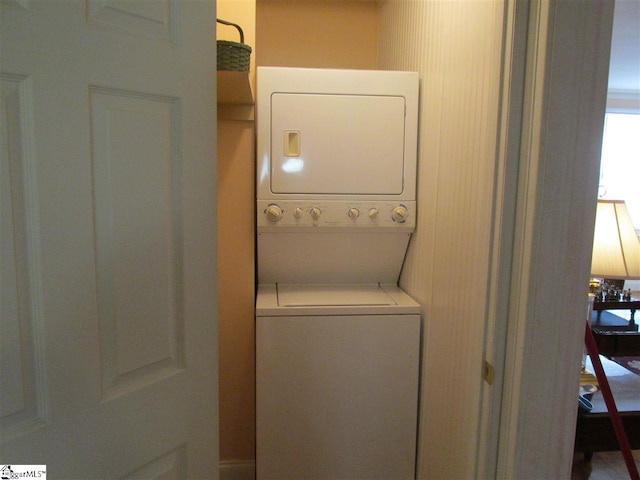 clothes washing area with stacked washer / dryer