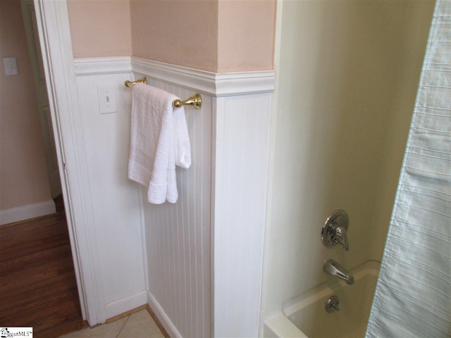 bathroom featuring shower / bathtub combination with curtain and hardwood / wood-style flooring