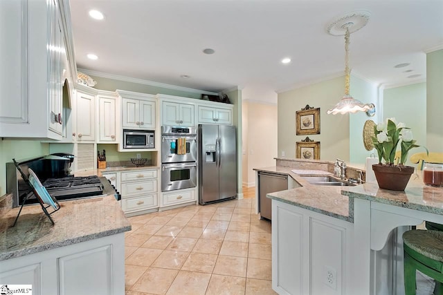 kitchen with appliances with stainless steel finishes, hanging light fixtures, light stone counters, and white cabinets