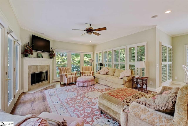 living room with a healthy amount of sunlight, ceiling fan, a fireplace, and light wood-type flooring