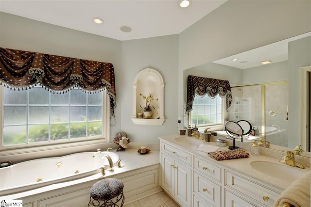 bathroom featuring a healthy amount of sunlight, large vanity, dual sinks, and tile flooring