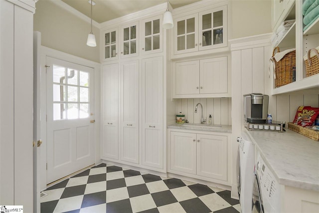 interior space with decorative light fixtures, light stone counters, white cabinetry, light tile floors, and sink