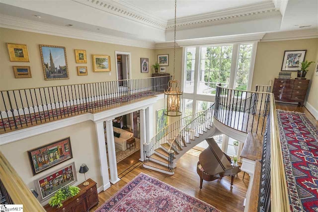 interior space with crown molding, hardwood / wood-style flooring, and a raised ceiling