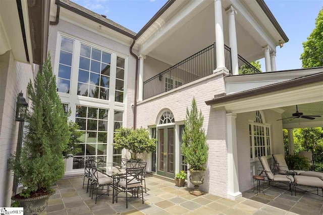 rear view of house with ceiling fan, a patio area, and french doors