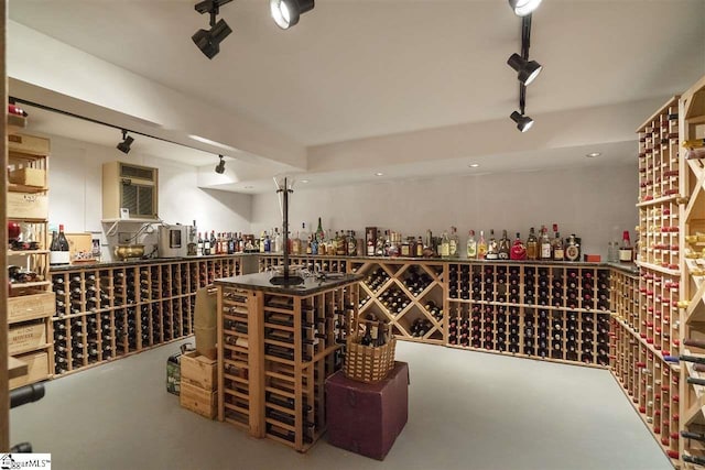 wine cellar featuring concrete flooring, rail lighting, and a wall mounted AC