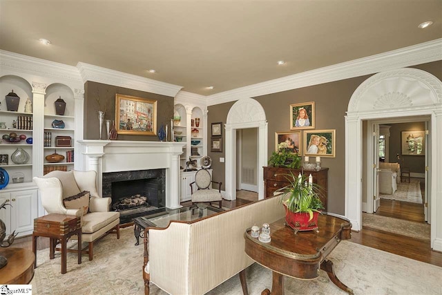 living room with ornamental molding, light hardwood / wood-style floors, and built in features