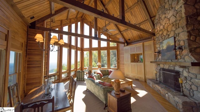 unfurnished sunroom with wooden ceiling, a fireplace, lofted ceiling with beams, and ceiling fan with notable chandelier