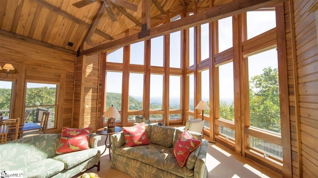 sunroom featuring wooden ceiling, ceiling fan, and vaulted ceiling with beams