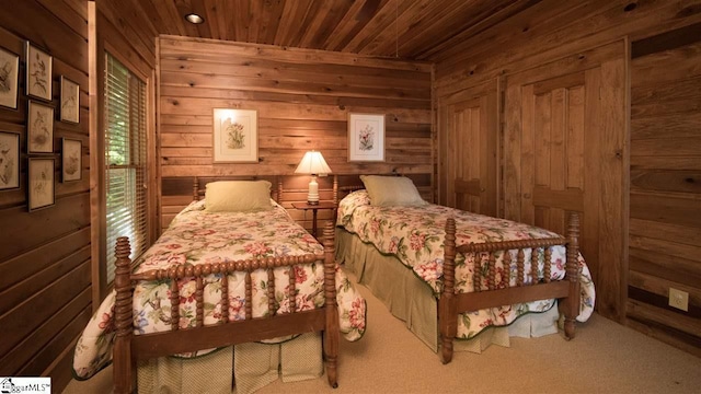 carpeted bedroom with wooden walls and wooden ceiling