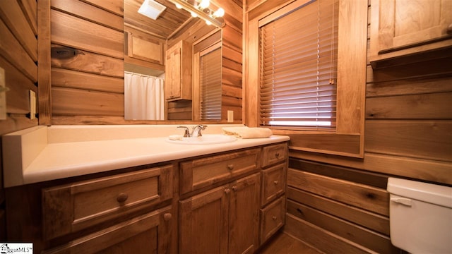 bathroom featuring toilet, wood ceiling, and oversized vanity