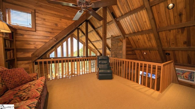 living area featuring ceiling fan, carpet floors, vaulted ceiling with beams, and wood ceiling