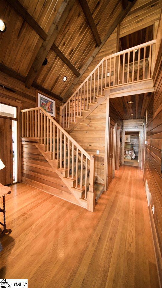 hall with wooden ceiling, light wood-type flooring, and beamed ceiling