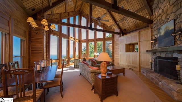 interior space featuring beam ceiling, high vaulted ceiling, wooden ceiling, and a fireplace