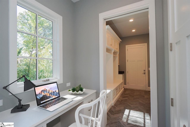 office space featuring a healthy amount of sunlight and dark parquet flooring