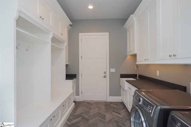 laundry area with sink, cabinets, dark parquet floors, and washer and dryer