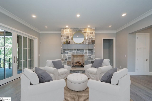 living room featuring crown molding, wood-type flooring, a stone fireplace, and french doors