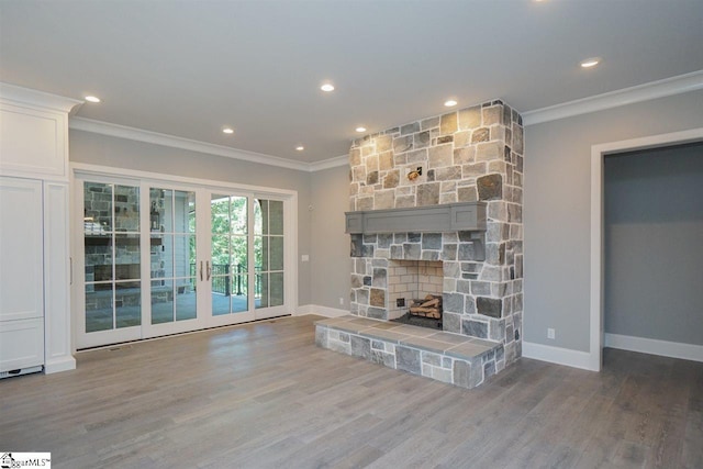 unfurnished living room with a stone fireplace, dark hardwood / wood-style floors, french doors, and ornamental molding