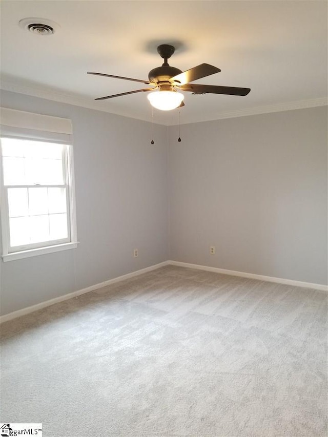 spare room featuring ornamental molding, light colored carpet, and ceiling fan