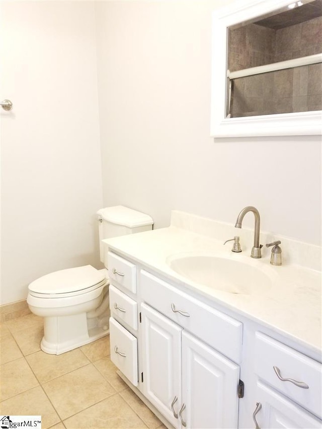 bathroom with toilet, tile floors, and vanity