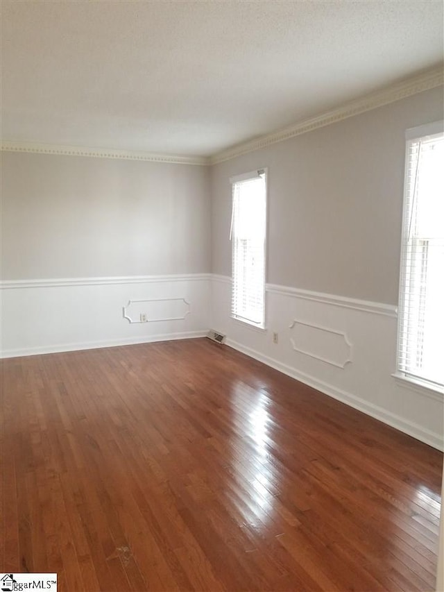 spare room featuring crown molding and dark hardwood / wood-style flooring