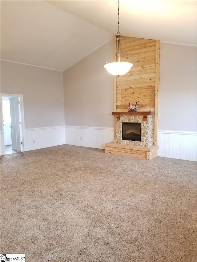 unfurnished living room featuring wood walls, carpet floors, a fireplace, and vaulted ceiling