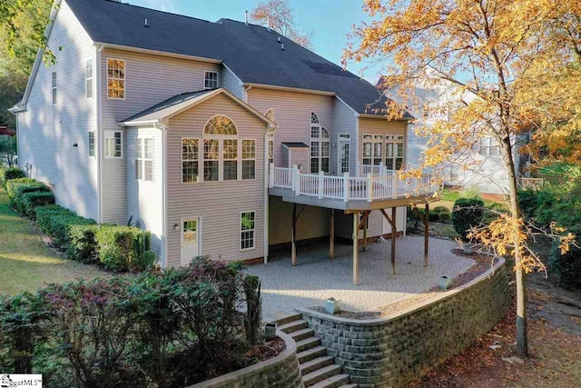 back of property featuring a patio and a wooden deck