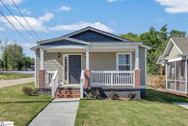 bungalow-style home with covered porch and a front yard