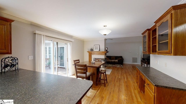 dining area with crown molding and light hardwood / wood-style flooring