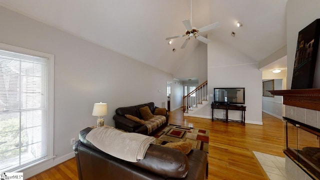 living room featuring high vaulted ceiling, ceiling fan, a healthy amount of sunlight, and light hardwood / wood-style flooring