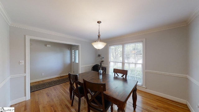 dining room featuring crown molding and light hardwood / wood-style floors