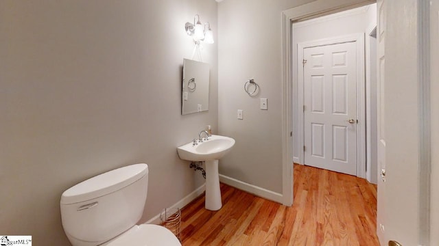 bathroom with toilet and hardwood / wood-style flooring