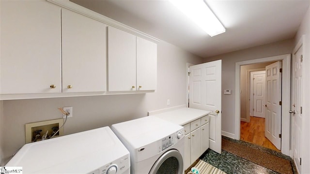 washroom featuring washer hookup, separate washer and dryer, cabinets, and hardwood / wood-style floors